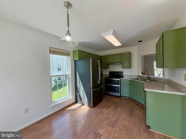 a kitchen with sink refrigerator and microwave