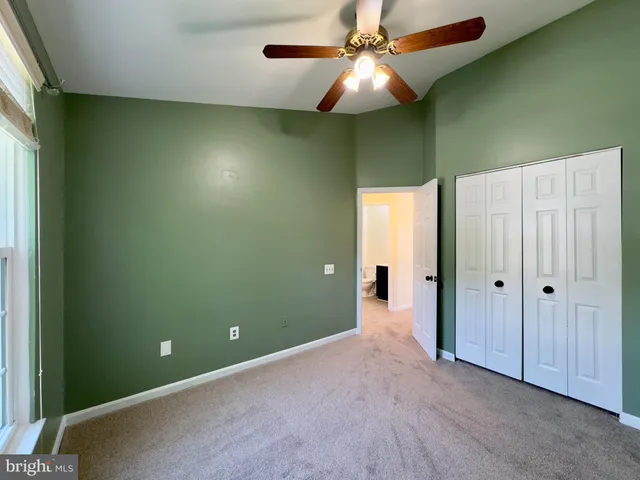 an empty room with closet and fan