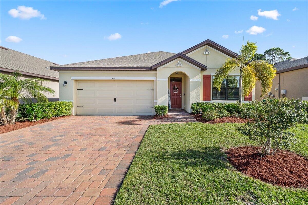 a front view of a house with a yard and garage