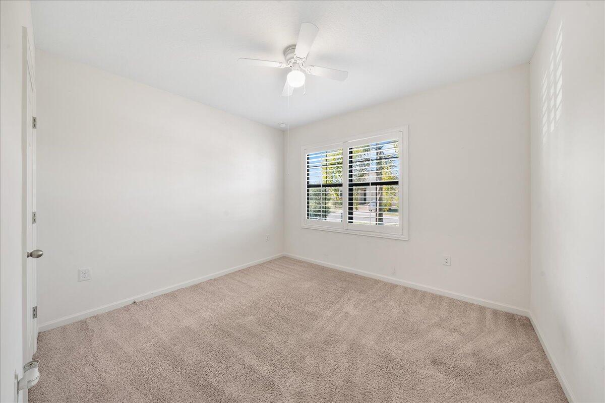 710 Old Country Rd S East Palm Bay, FL 32909 - Photo 16 of 27 an empty room with windows and ceiling fan