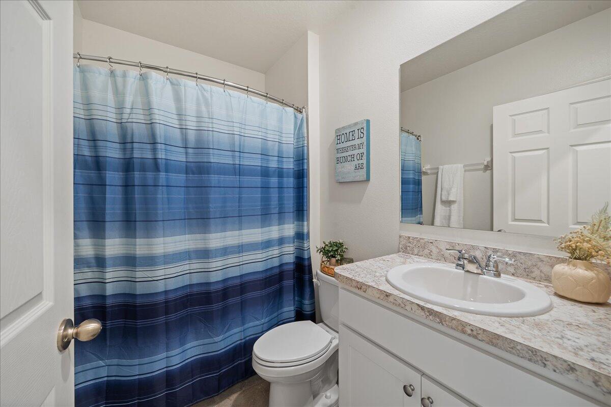 710 Old Country Rd S East Palm Bay, FL 32909 - Photo 18 of 27 a bathroom with a sink a toilet and shower curtain