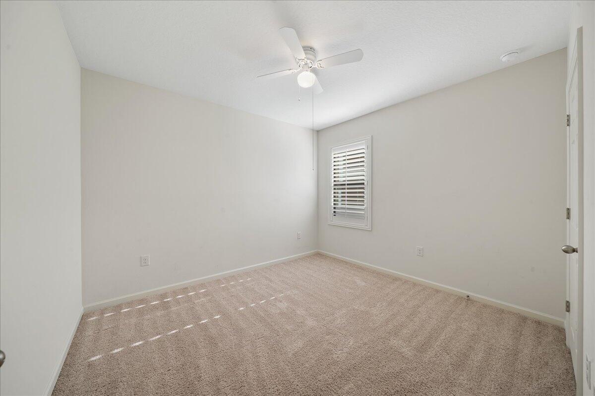 710 Old Country Rd S East Palm Bay, FL 32909 - Photo 19 of 27 an empty room with windows and fan