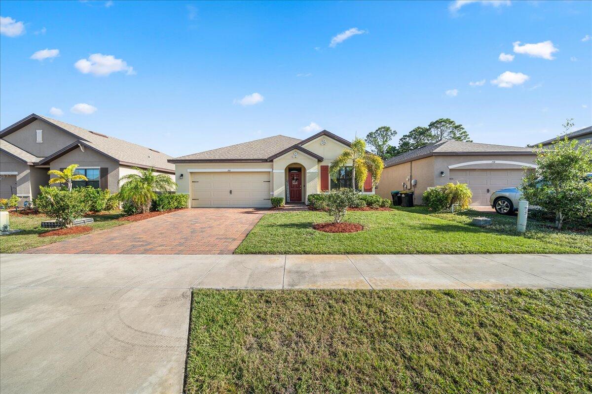 710 Old Country Rd S East Palm Bay, FL 32909 - Photo 24 of 27 a front view of a house with a yard and garage