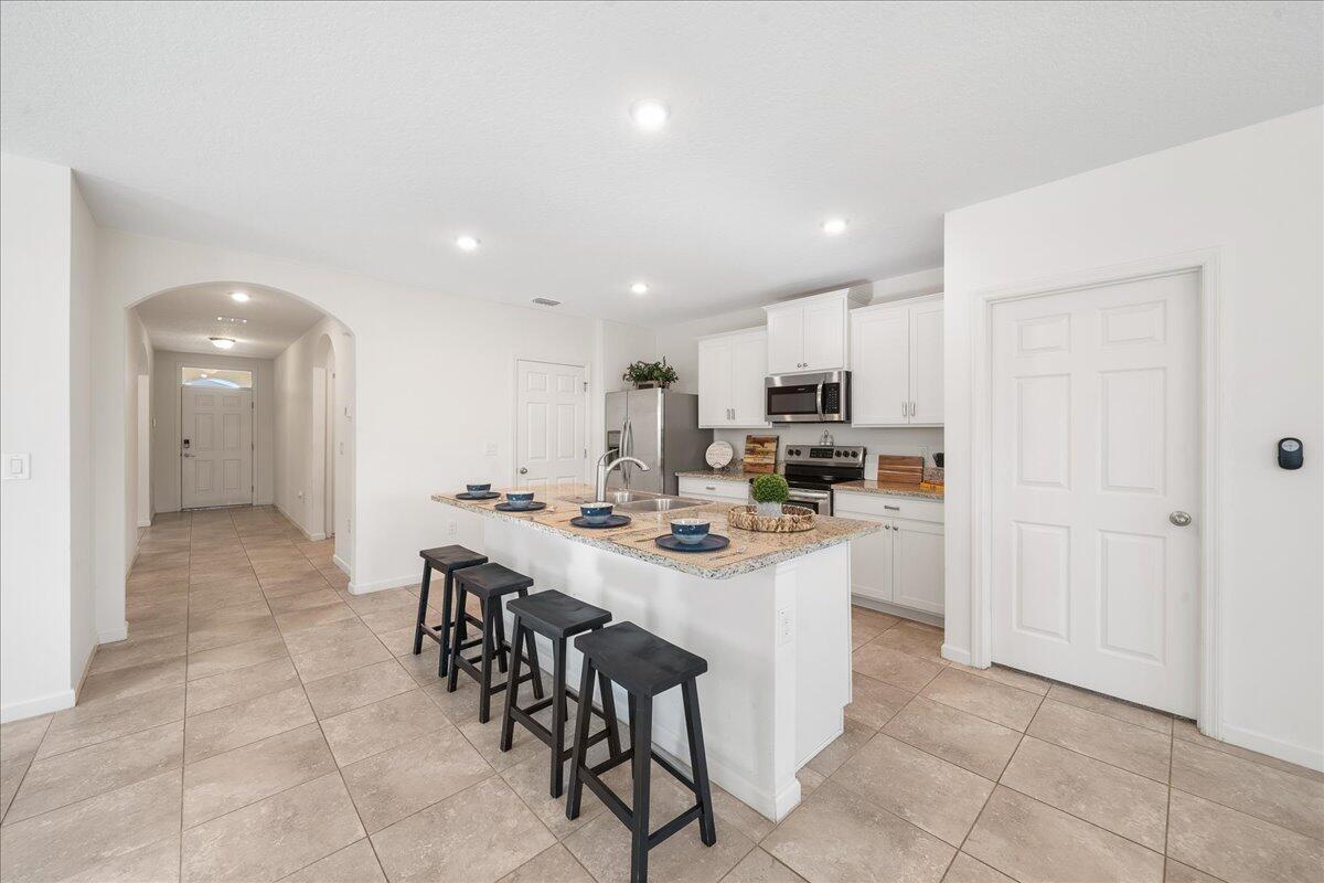 710 Old Country Rd S East Palm Bay, FL 32909 - Photo 6 of 27 a kitchen with a sink a counter top space and stainless steel appliances