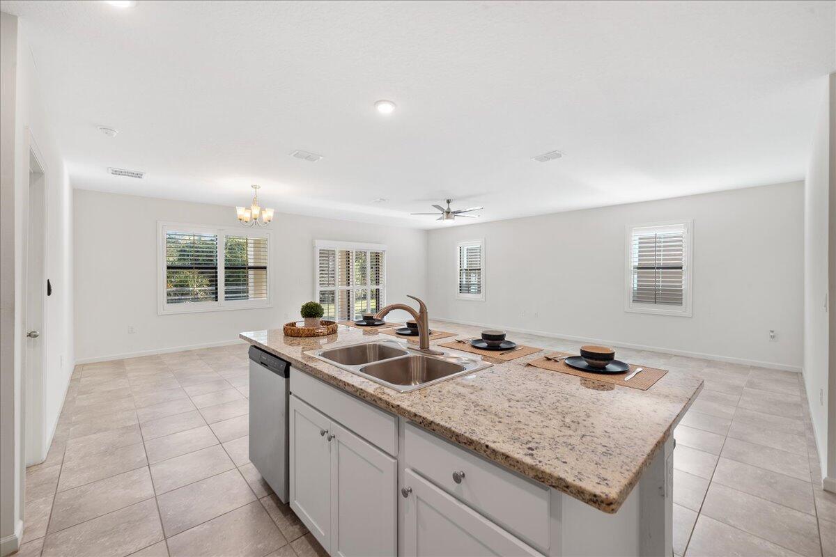 710 Old Country Rd S East Palm Bay, FL 32909 - Photo 7 of 27 a kitchen with stainless steel appliances granite countertop a sink and a white cabinets