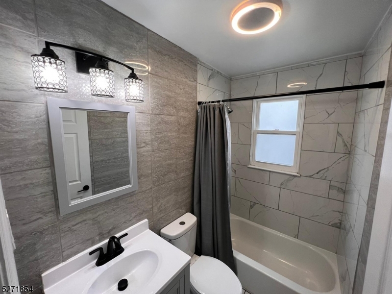 a bathroom with a sink and mirror with bathtub