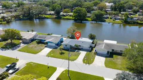 an aerial view of a house with outdoor seating space and a lake view