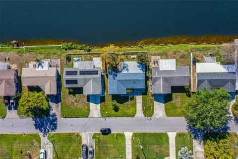 an aerial view of residential houses with outdoor space and trees all around