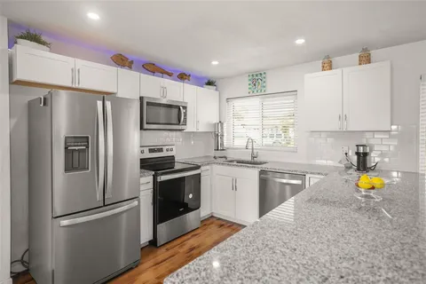 a kitchen with stainless steel appliances granite countertop a sink and a granite counter tops