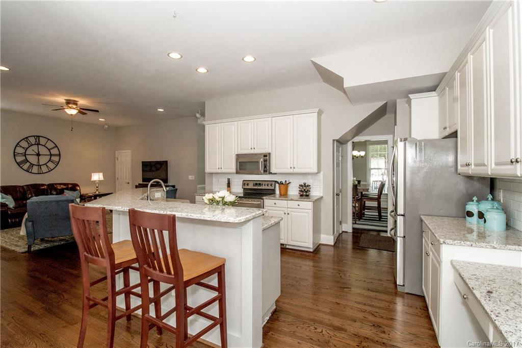 618 Lena Way Fort Mill, SC 29708 - Photo 11 of 24 a kitchen with stainless steel appliances kitchen island granite countertop a table chairs sink and cabinets