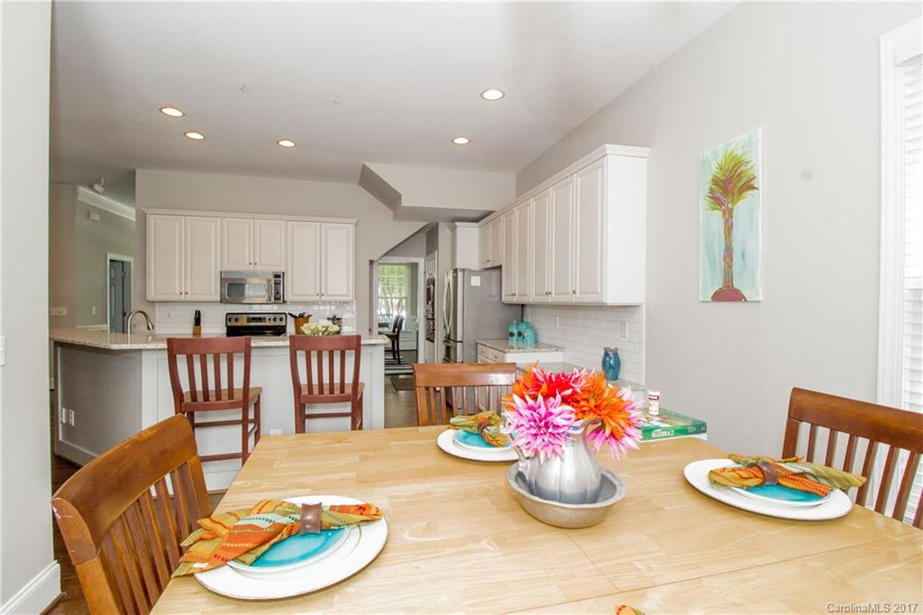 618 Lena Way Fort Mill, SC 29708 - Photo 9 of 24 a kitchen with stainless steel appliances kitchen island granite countertop a dining table and chairs