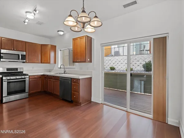 a kitchen with stainless steel appliances granite countertop wooden floors a stove a sink and dishwasher