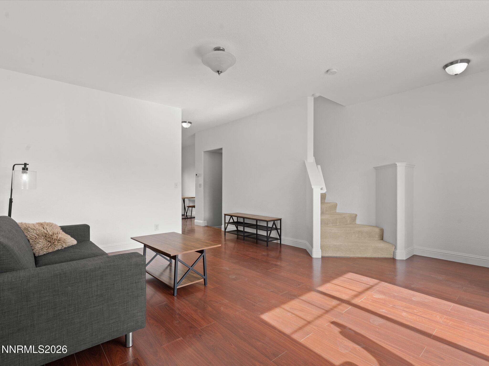 4795 Ciarra Kennedy Lane Reno, NV 89503 - Photo 18 of 37 a living room with furniture and a dining table with wooden floor