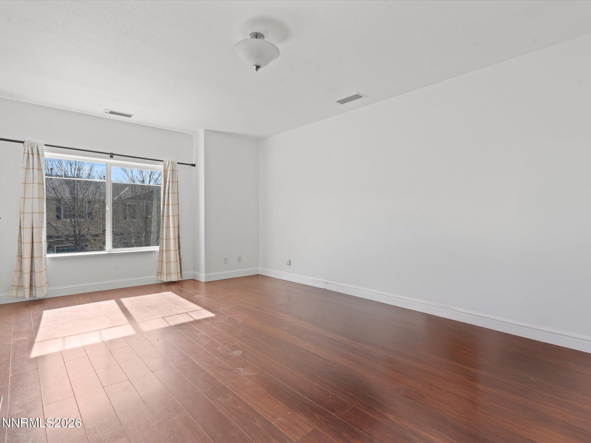 4795 Ciarra Kennedy Lane Reno, NV 89503 - Photo 20 of 37 a view of an empty room with wooden floor and a window