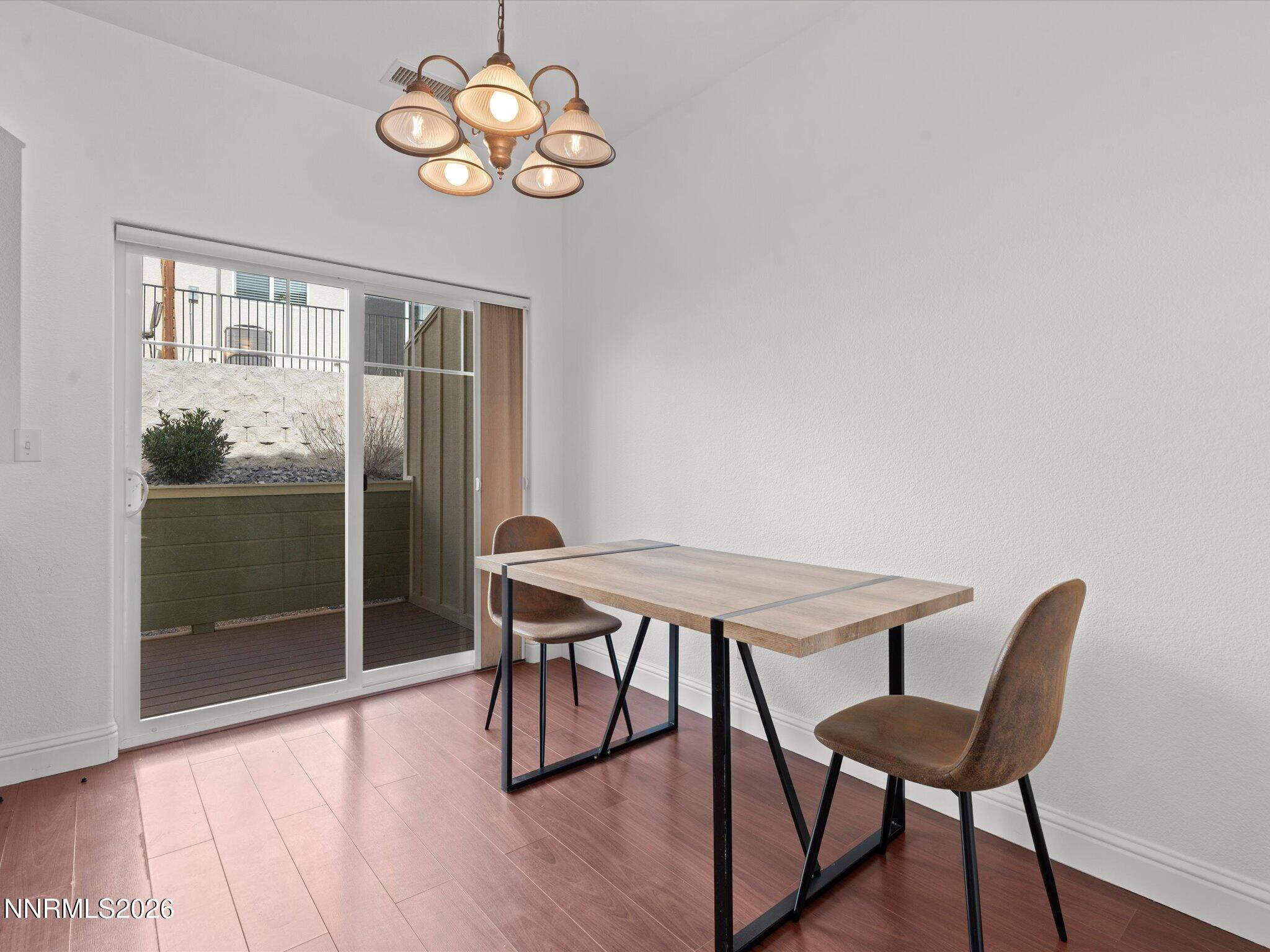 4795 Ciarra Kennedy Lane Reno, NV 89503 - Photo 21 of 37 a view of a dining room with furniture wooden floor and a chandelier