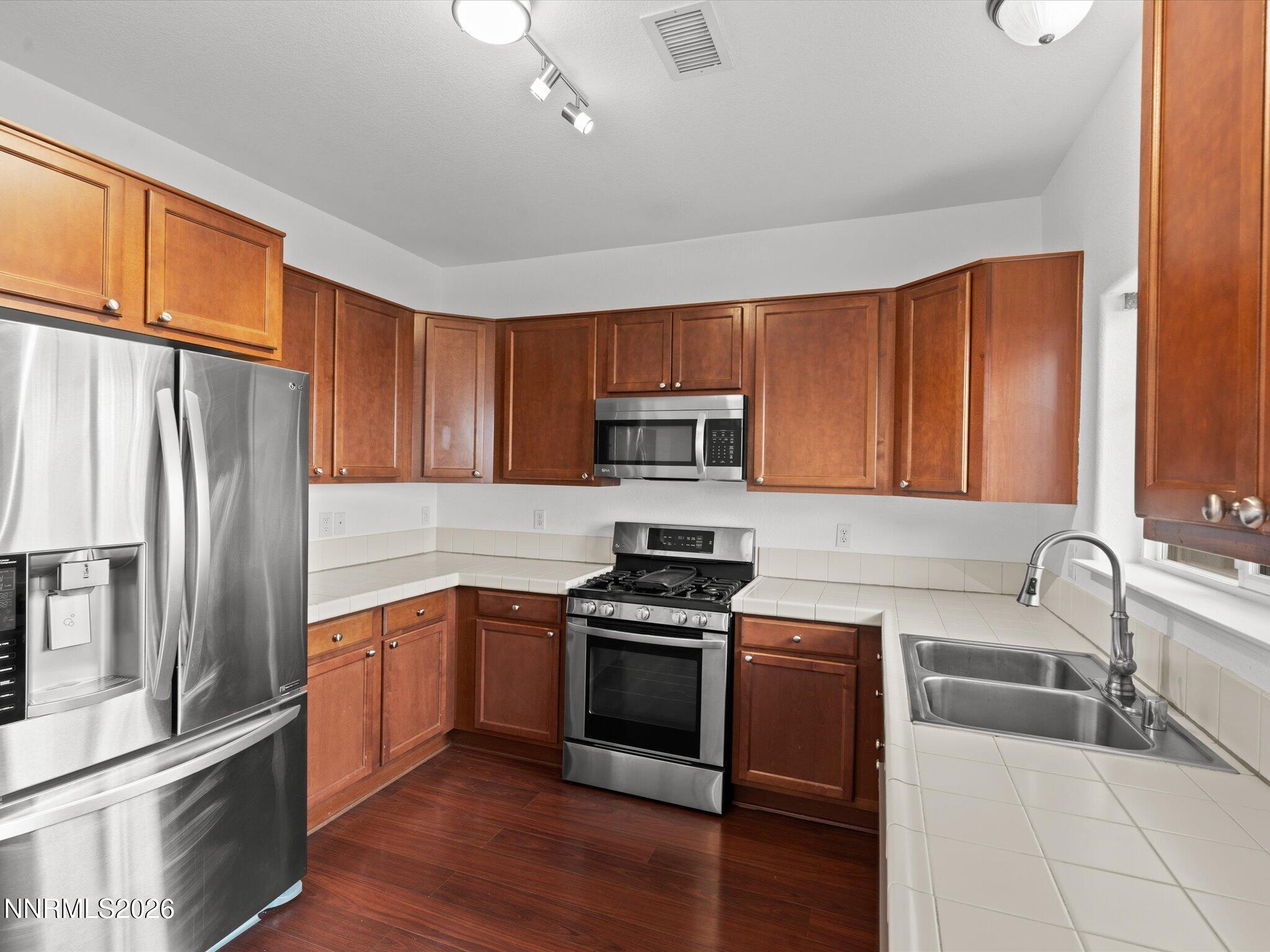 4795 Ciarra Kennedy Lane Reno, NV 89503 - Photo 22 of 37 a kitchen with stainless steel appliances granite countertop a refrigerator stove and sink