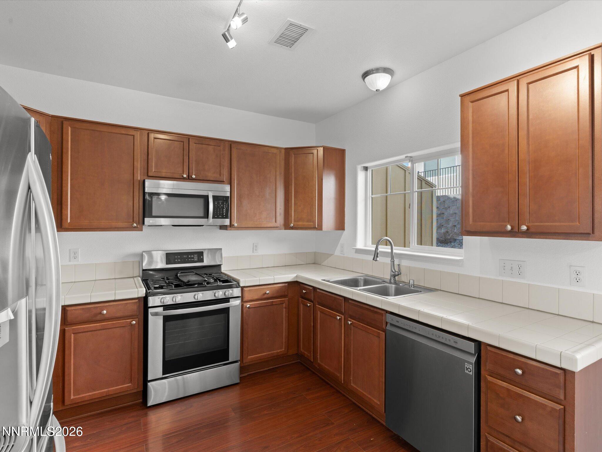 4795 Ciarra Kennedy Lane Reno, NV 89503 - Photo 23 of 37 a kitchen with stainless steel appliances a sink cabinets and a window