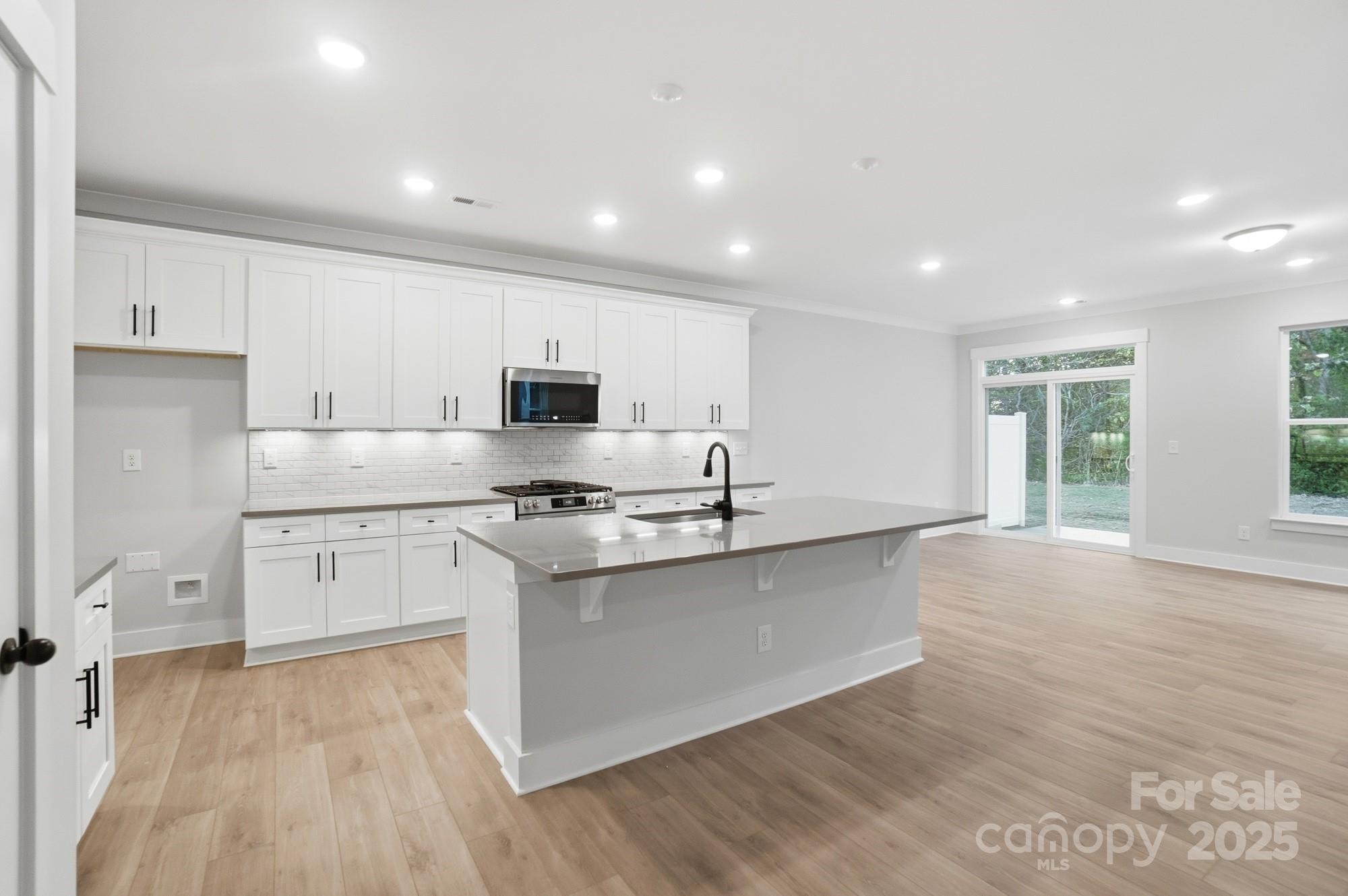 123 Viburnum Road Waxhaw, NC 28173 - Photo 4 of 28 a large kitchen with stainless steel appliances granite countertop a stove a sink and white cabinets