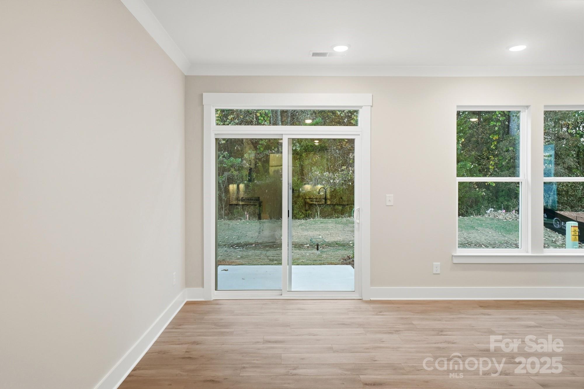 123 Viburnum Road Waxhaw, NC 28173 - Photo 7 of 28 a view of an empty room with wooden floor and a window