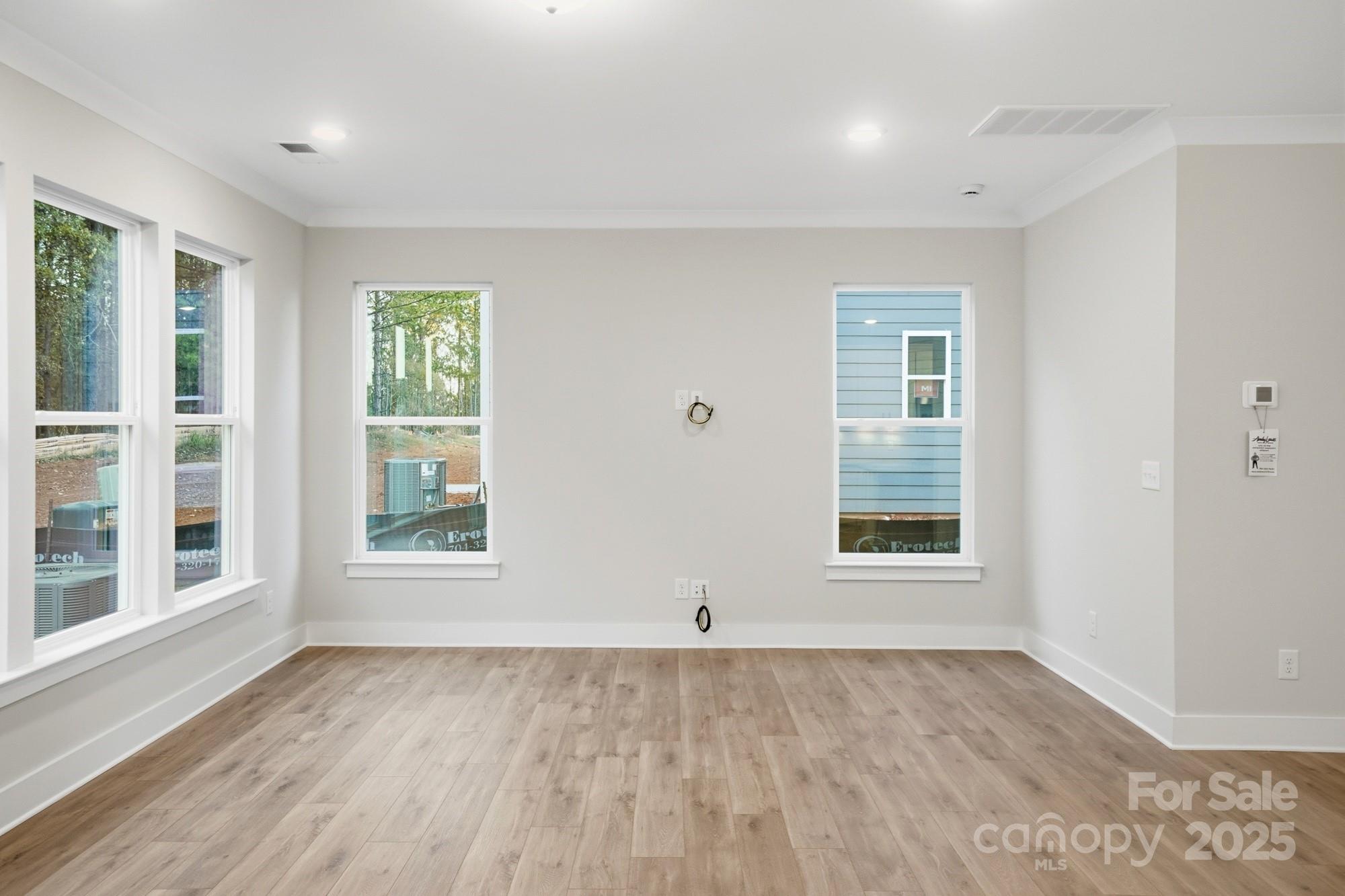 123 Viburnum Road Waxhaw, NC 28173 - Photo 8 of 28 an empty room with wooden floor and windows