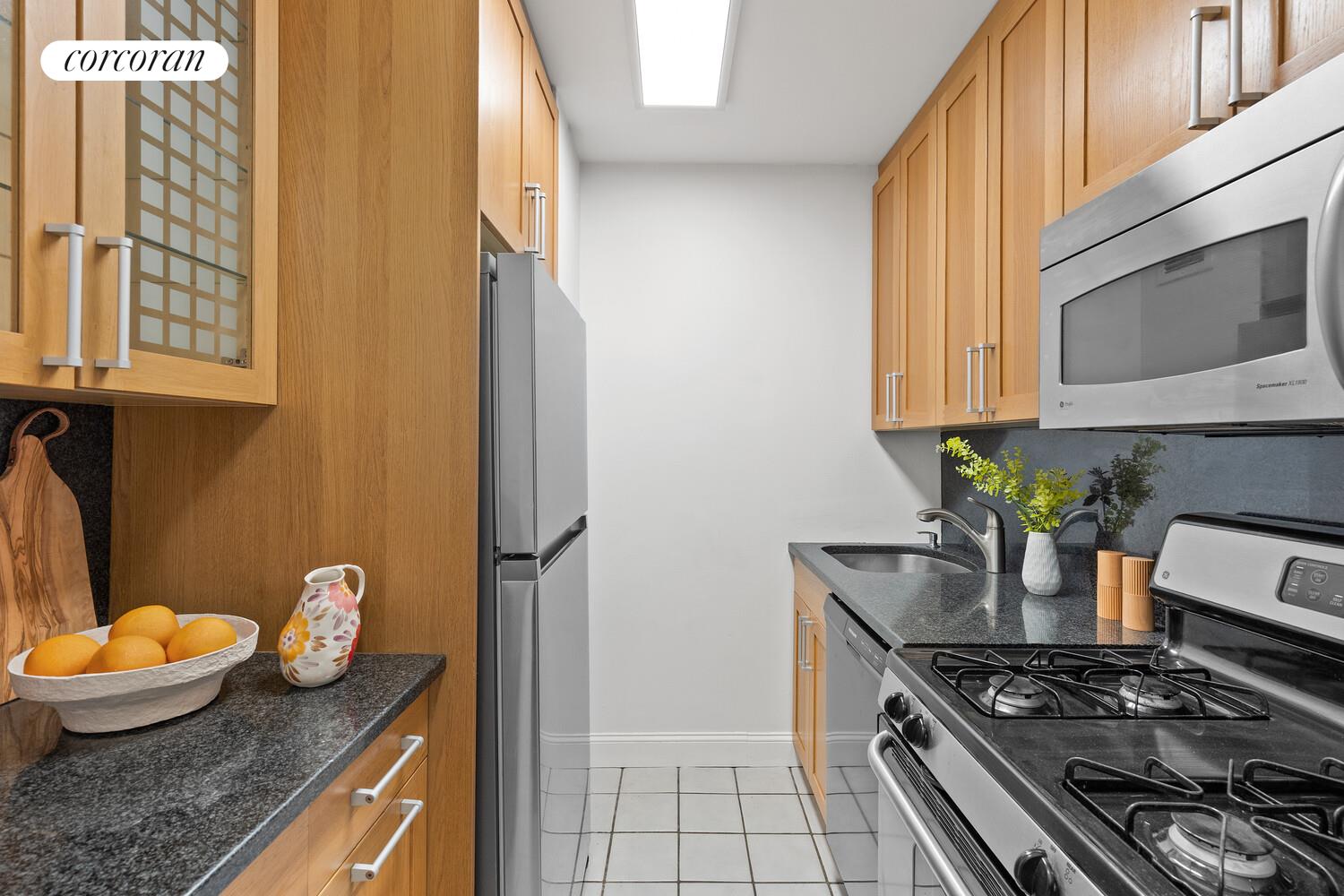 2025 Broadway, Unit 17F Manhattan, NY 10023 - Photo 6 of 15 a kitchen with stainless steel appliances granite countertop a stove and a microwave