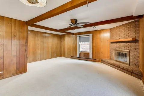 a view of an empty room with a fireplace and a window