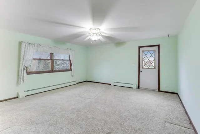 an empty room with windows and ceiling fan
