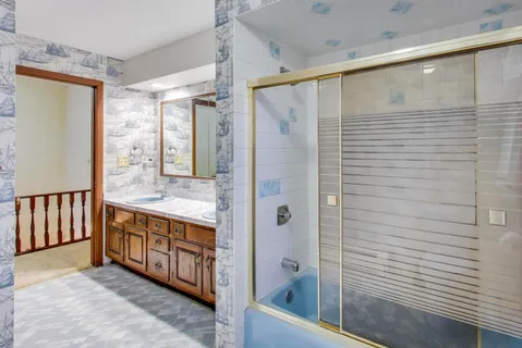 a bathroom with a tub shower and sink