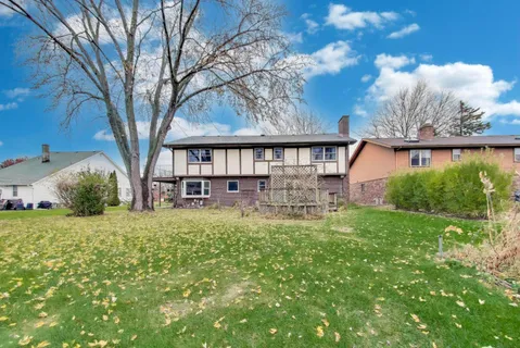 a view of backyard of house with green space