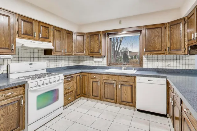 a kitchen with stainless steel appliances granite countertop a stove sink and cabinets