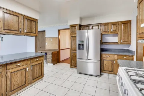a kitchen with stainless steel appliances granite countertop a refrigerator and a stove top oven