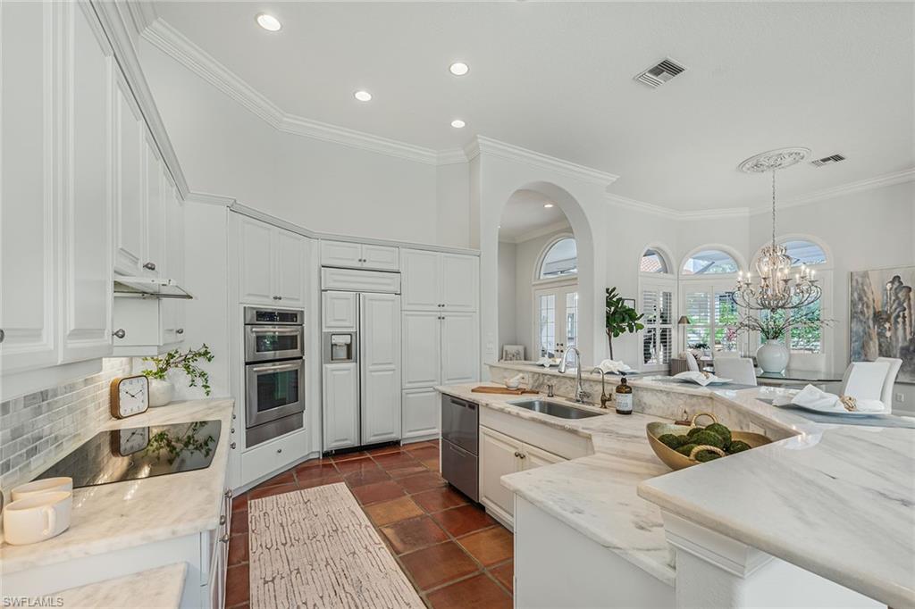 6648 Glen Arbor Way Naples, FL 34119 - Photo 13 of 47 a large white kitchen with a stove a sink and a refrigerator