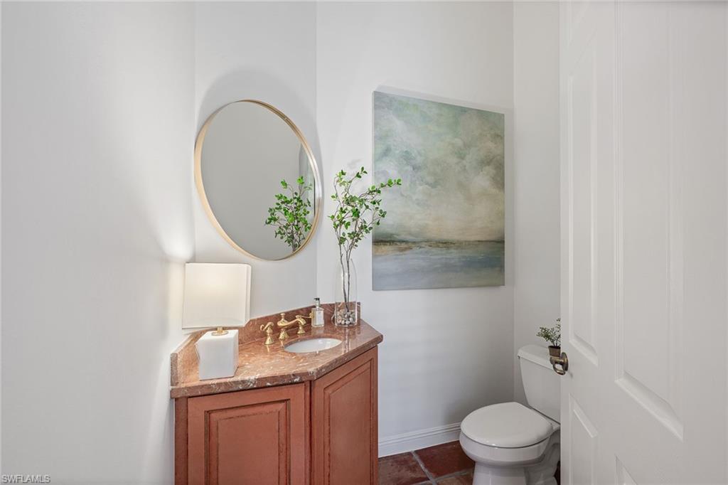 6648 Glen Arbor Way Naples, FL 34119 - Photo 21 of 47 a bathroom with a granite countertop toilet a sink and mirror