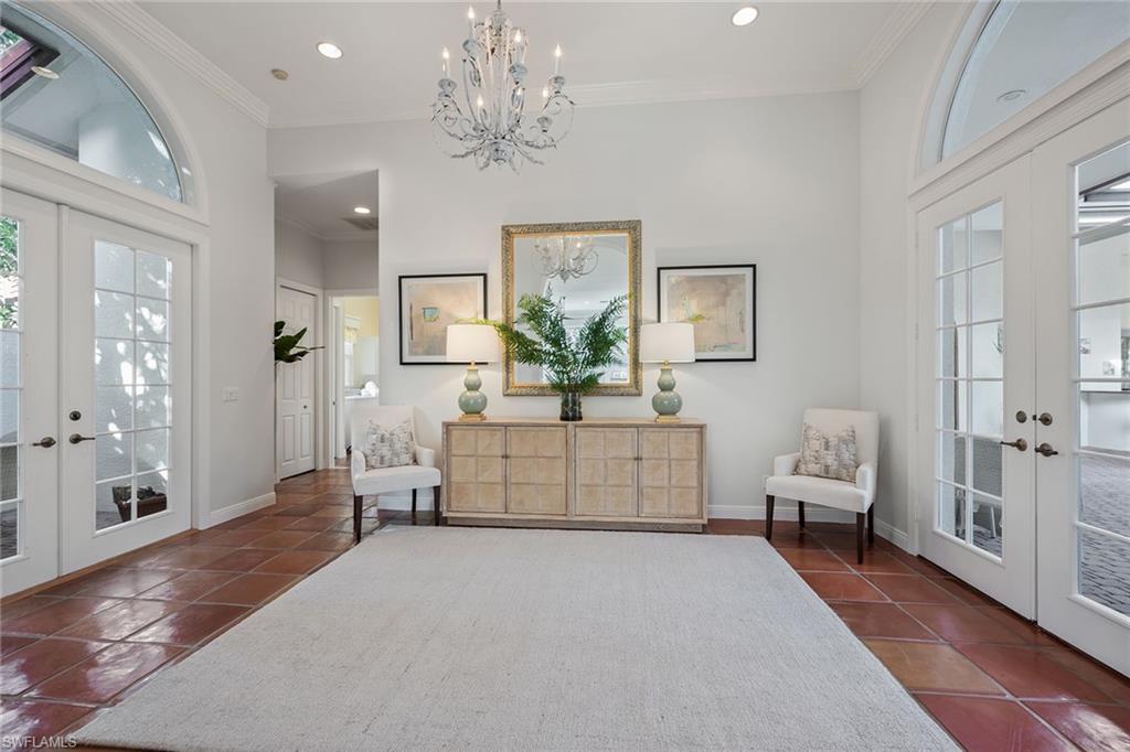 6648 Glen Arbor Way Naples, FL 34119 - Photo 6 of 47 a living room with furniture and a chandelier