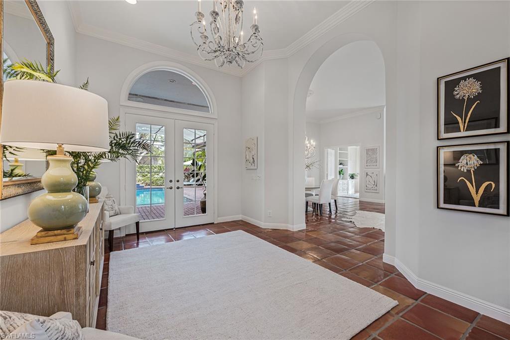 6648 Glen Arbor Way Naples, FL 34119 - Photo 7 of 47 a living room with furniture and a chandelier