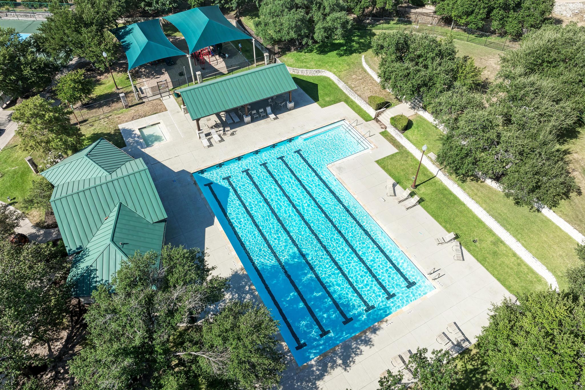 906 Antelope Ridge Cedar Park, TX 78613 - Photo 37 of 40 An aerial view showcases a sparkling lap pool surrounded by lush green lawns and shade structures.