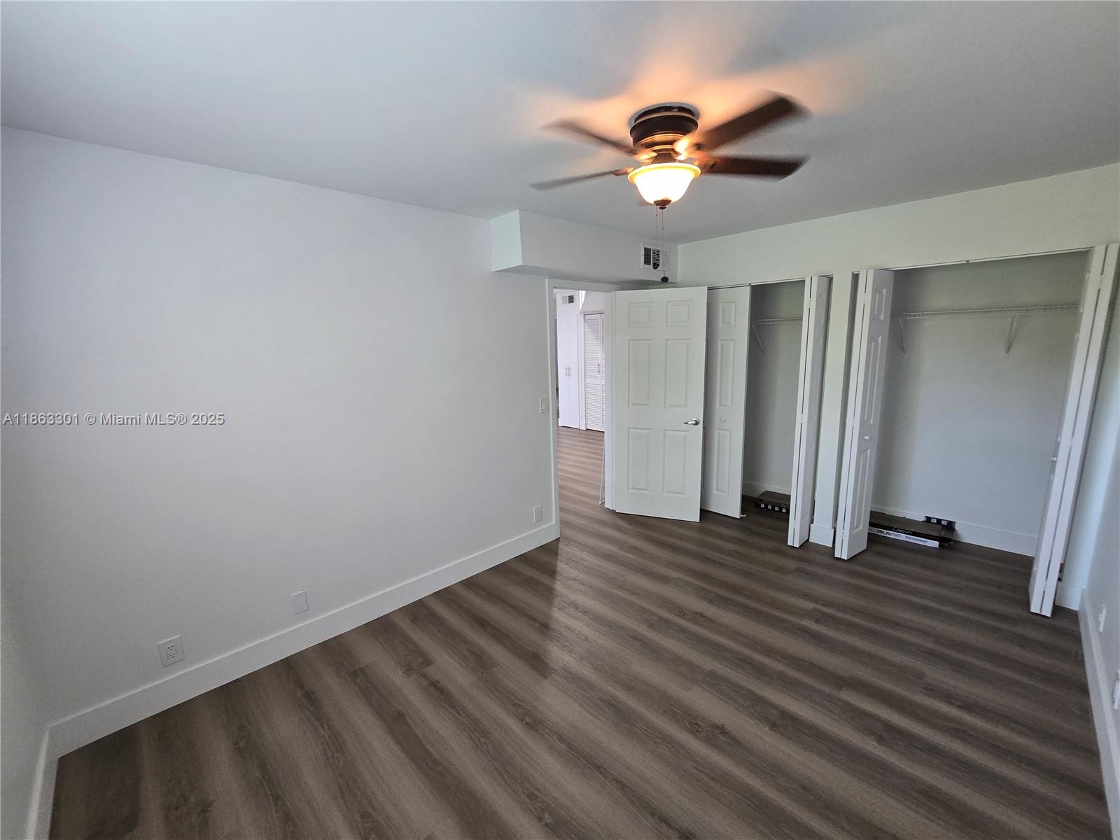 8886 Southwest 3rd Street, Unit 202 Pembroke Pines, FL 33025 - Photo 18 of 36 an empty room with wooden floor ceiling fan and window