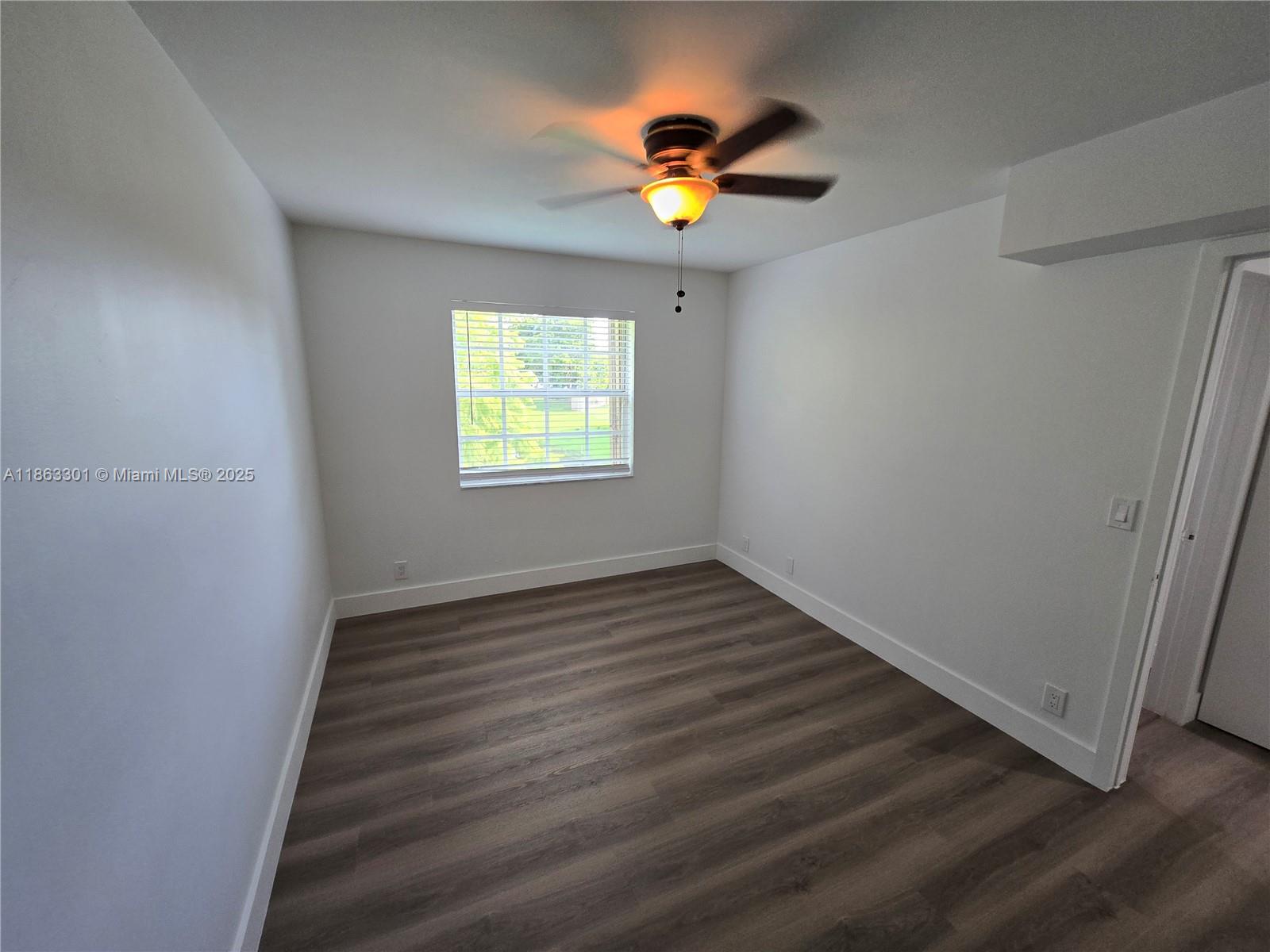 8886 Southwest 3rd Street, Unit 202 Pembroke Pines, FL 33025 - Photo 20 of 36 an empty room with wooden floor and chandelier fan