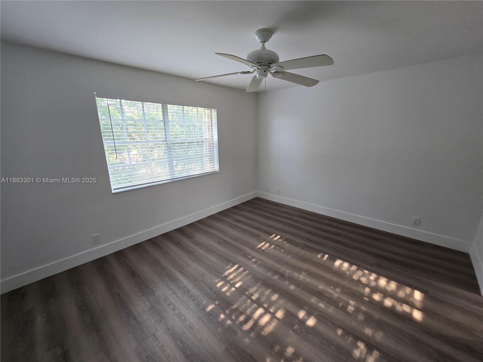 8886 Southwest 3rd Street, Unit 202 Pembroke Pines, FL 33025 - Photo 25 of 36 a view of an empty room with wooden floor and a window