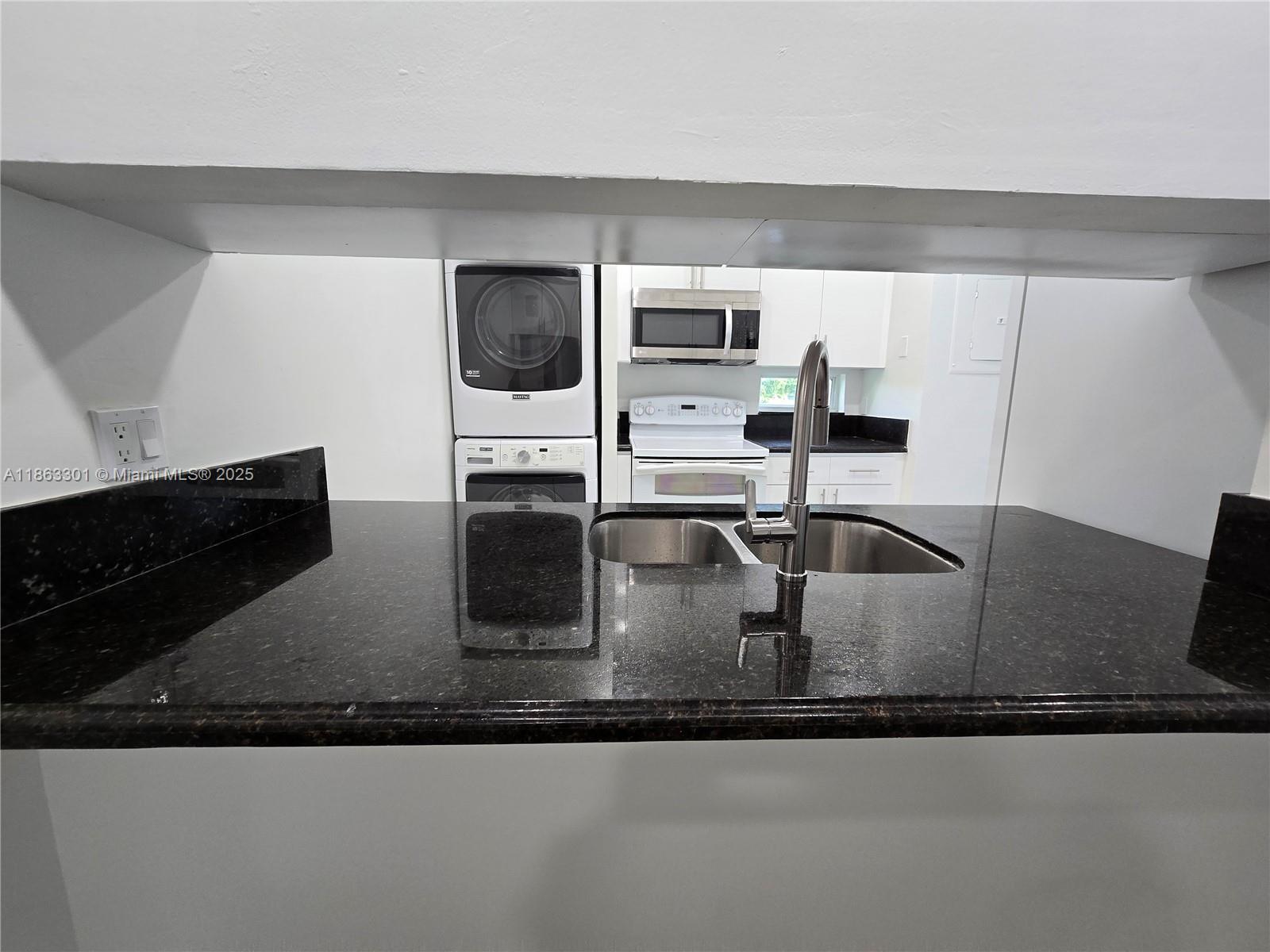 8886 Southwest 3rd Street, Unit 202 Pembroke Pines, FL 33025 - Photo 4 of 36 a kitchen with stainless steel appliances granite countertop a sink a microwave a stove and white cabinets