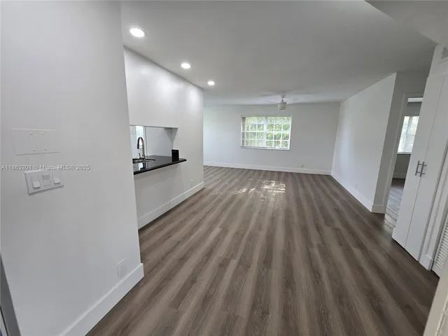 a view of a kitchen with wooden floor and electronic appliances