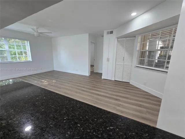 a view of empty room with wooden floor and window