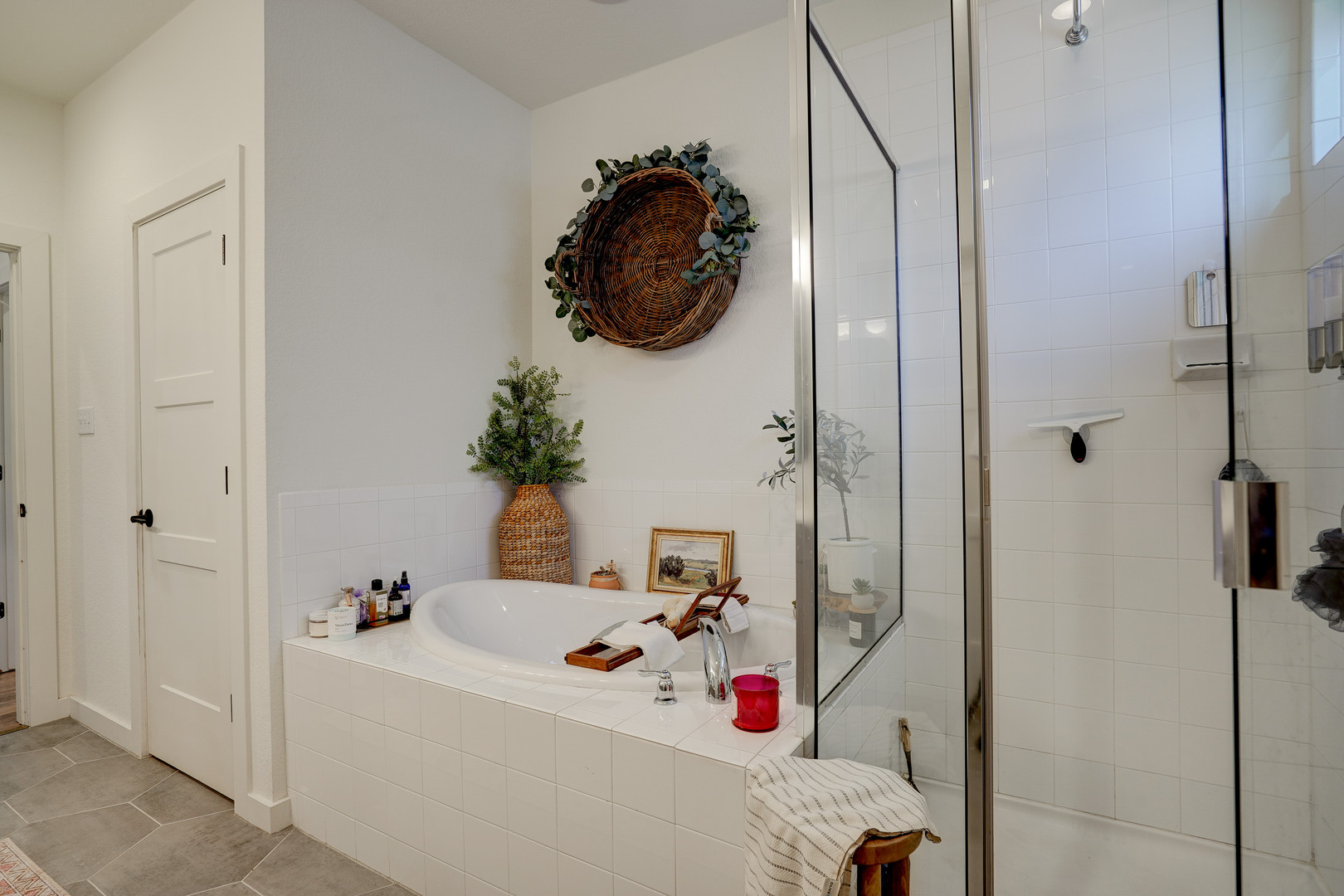 2240 Ringstaff Road Leander, TX 78641 - Photo 16 of 25 Built-in soaking tub with surrounding white tile, walk-in shower with glass enclosure, white paneled interior doors, and flagstone-style flooring