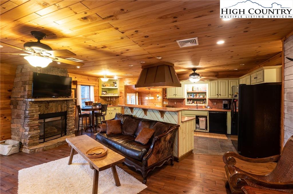 6218 Junaluska Road Boone, NC 28607 - Photo 8 of 33 a living room with furniture a flat screen tv and kitchen view