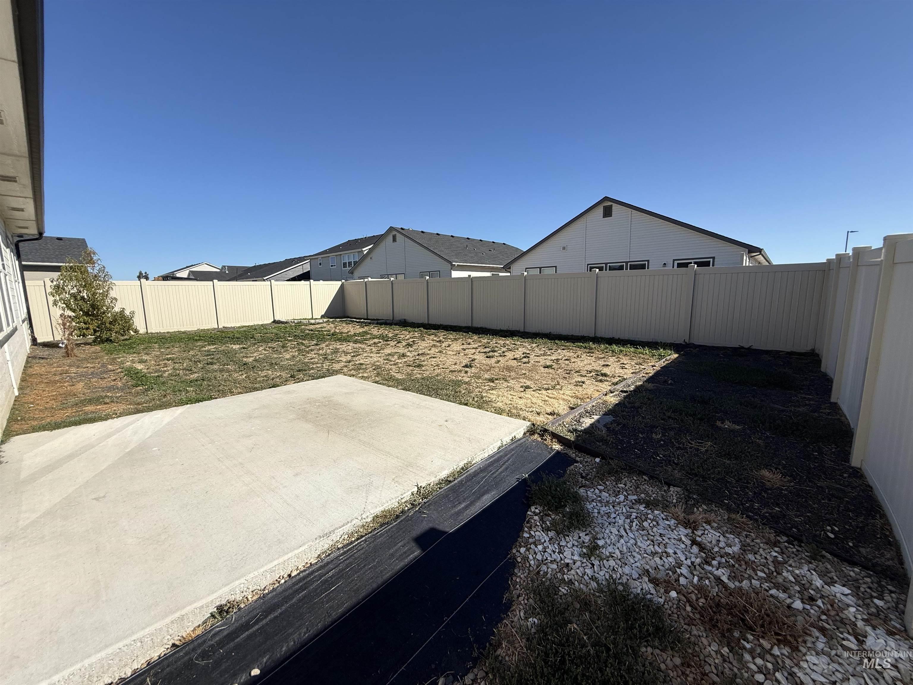 12451 Varga Street Caldwell, ID 83607 - Photo 26 of 30 Expansive backyard featuring a concrete patio, full perimeter fencing, and partial landscaping