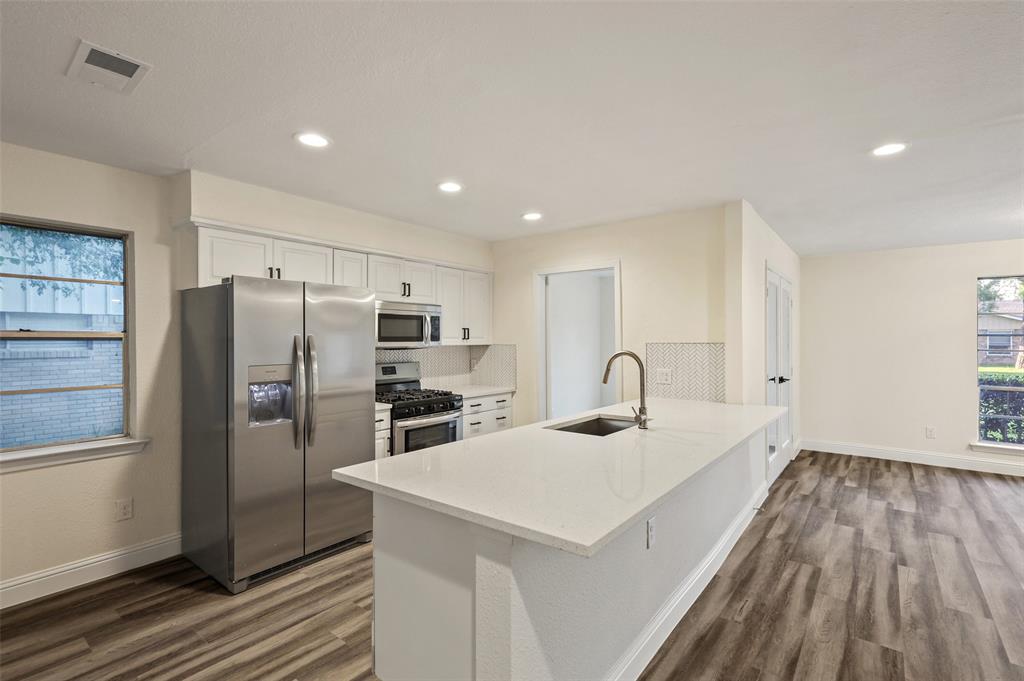 3126 Jubilee Trail Dallas, TX 75229 - Photo 7 of 38 a kitchen with a sink a refrigerator and wooden floor