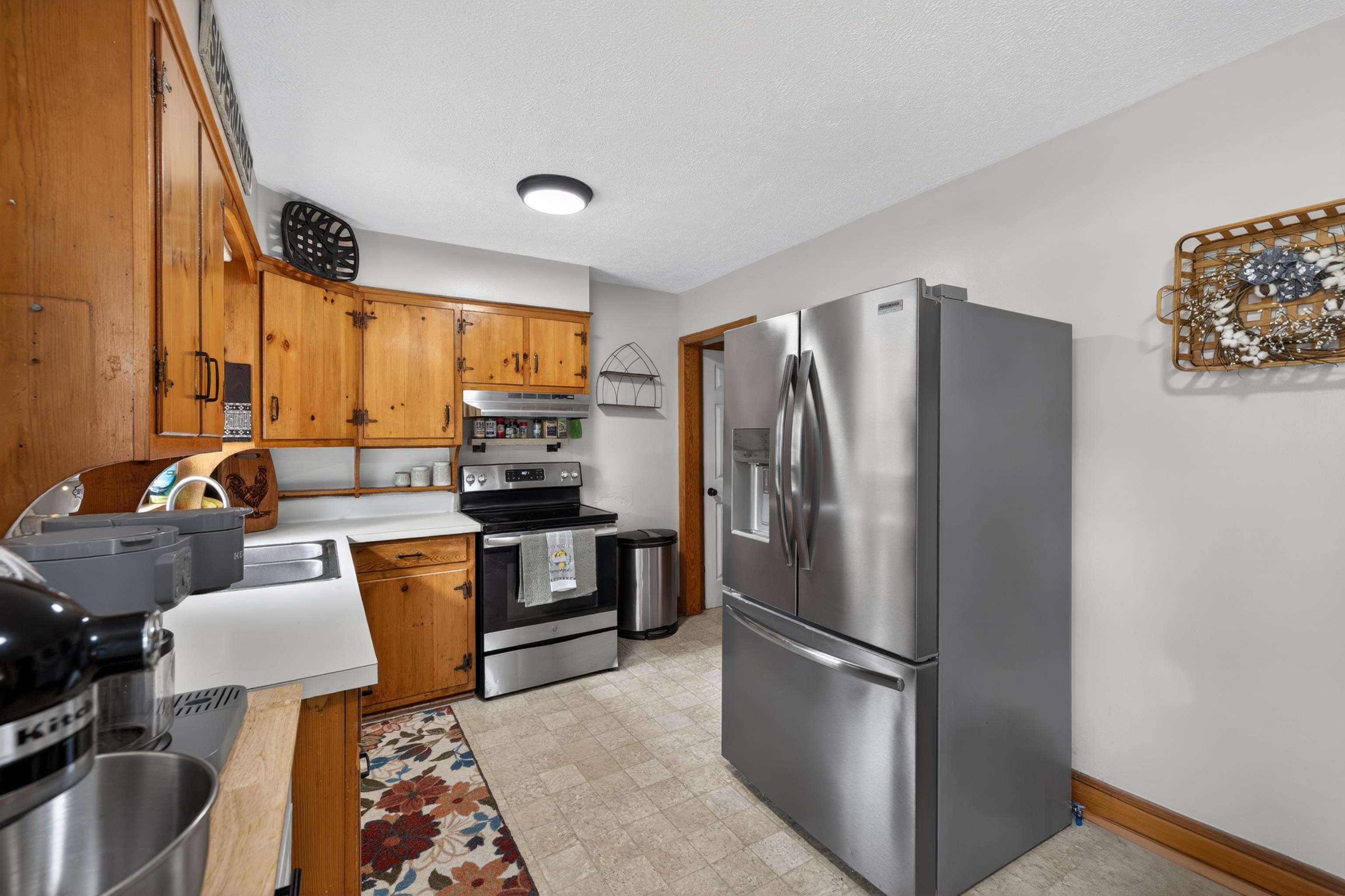 7827 Lee Highway Raphine, VA 24472 - Photo 24 of 62 a kitchen with stainless steel appliances granite countertop a refrigerator a stove a sink a dining table and chairs