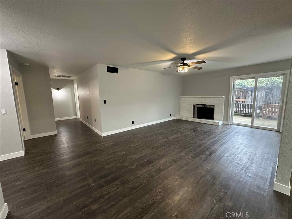 1939 Sierra Court Merced, CA 95340 - Photo 5 of 22 an empty room with wooden floor fan and windows