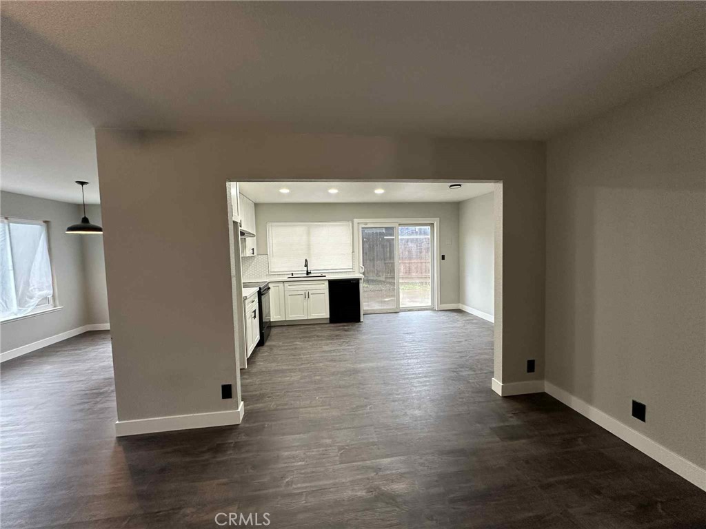 1939 Sierra Court Merced, CA 95340 - Photo 8 of 22 a view of a hallway with wooden floor and a kitchen