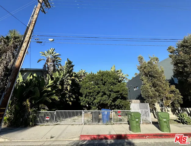 front view of a house with a yard and potted plants